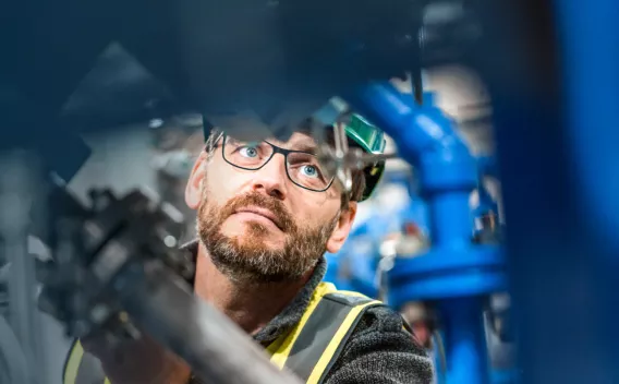 ouvrier du bâtiment vu à travers des tuyaux